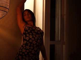 Sensual Latina Doing a Striptease in Low Light