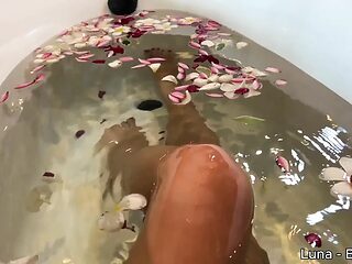 Naked MILF teases and masturbates in a bath of flowers