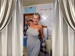 An Old Woman Flirts in the Kitchen While Taking off Her Clothes