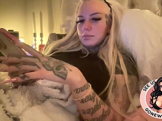 Inked Blonde Bombshell Holding Toys in Bed