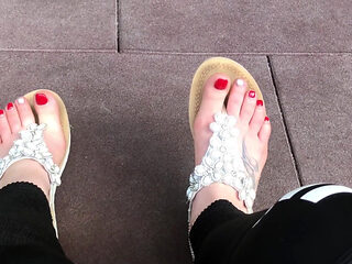 Sandals teasing outdoor with red toenails & toes wiggling